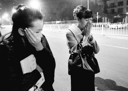 图为在事故现场,女司机(右)掩面而泣,受轻伤的出租车乘客站在旁边