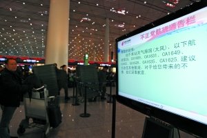 昨日,首都机场T3航站楼内,显示屏上显示由于大风天气被取消的航班。本报记者 孙纯霞 摄