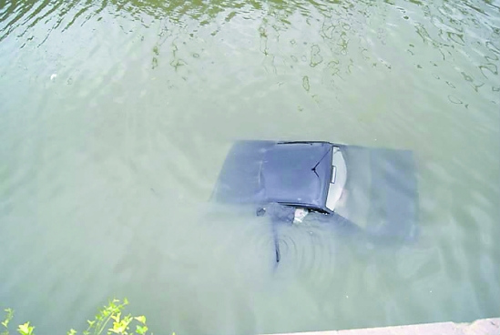 轿车被撞坠入河中4名路人用竹竿拉起落水者