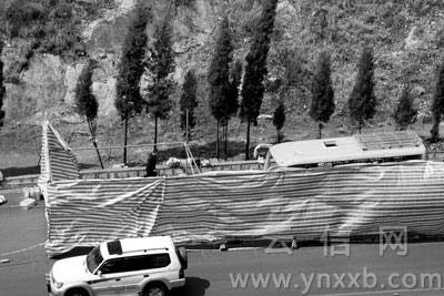 昨日，出事的中巴车还在现场，占了半个车道，已经被警方用防雨棚围起来。