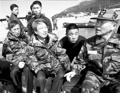 28日,在韩国白翎岛,总理郑云灿(前左二)坐橡皮艇查看“天安”号沉没地点。 图/人民图片