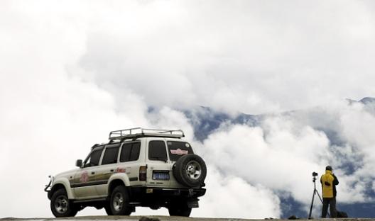 一名自驾游旅行者在川藏公路林芝境内拍摄风光 一名自驾游旅行者在川藏公路林芝境内拍摄风光